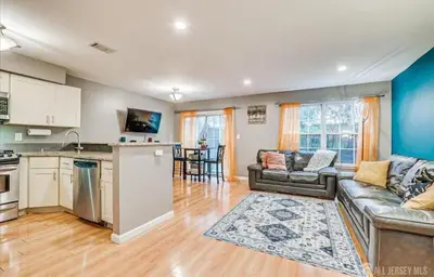 a large living room with a couch and a kitchen at Comfortable Private Room with Bath Easy Transit in Piscataway