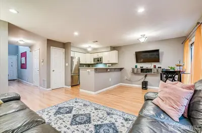 a living room with a couch and a kitchen at Comfortable Private Room with Bath Easy Transit in Piscataway