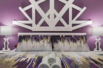 a bedroom with a white bed with purple walls at Moon Mtn Manor Sleeps 16 Karaoke Hot Tub in Albrightsville