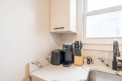 a kitchen counter with a sink and a window at Modern 2BR 8 mins to Penn Station with WiFi Laundry in Newark
