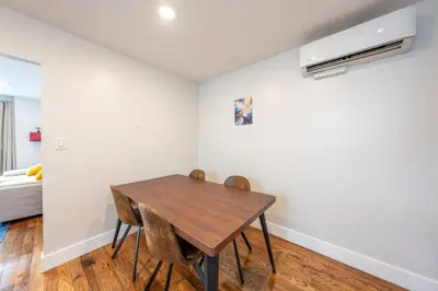 a dining room with a wooden table and chairs at Modern 2BR 8 mins to Penn Station with WiFi Laundry in Newark