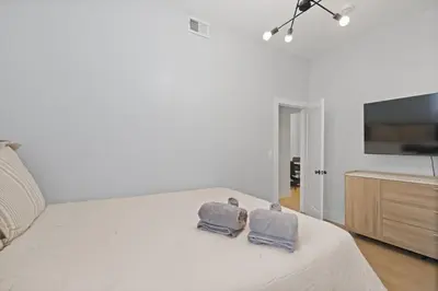 a bedroom with a bed with two towels on it at Cozy and Modern 3BR Apartment 5min to PATH to NYC in Jersey City