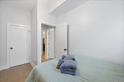 a stuffed animal sitting on a bed in a bedroom at Cozy and Modern 3BR Apartment 5min to PATH to NYC in Jersey City