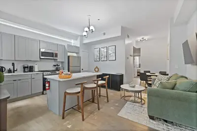 a kitchen and living room with a couch and a table at Cozy and Modern 3BR Apartment 5min to PATH to NYC in Jersey City