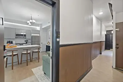 a kitchen and living room with a couch and a table at Cozy and Modern 3BR Apartment 5min to PATH to NYC in Jersey City