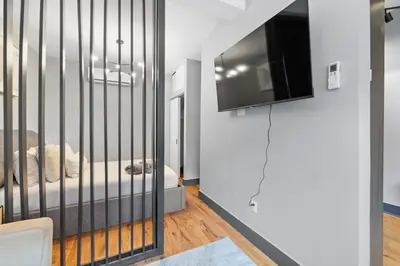a bedroom with a crib with a television in it at Modern & Cozy Studio in Jersey 20 Min to New York in Jersey City