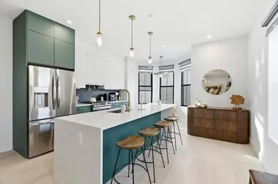 a kitchen with a large island with stools at Designer Luxury Duplex a few mintues to NYC with Skyline Views in Jersey City
