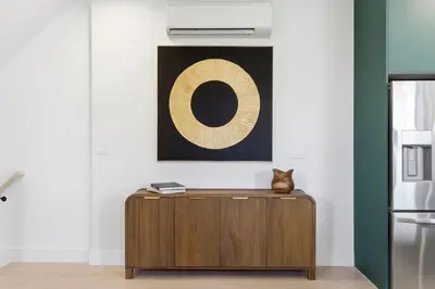 a cat sitting on top of a wooden cabinet in a kitchen at Designer Luxury Duplex a few mintues to NYC with Skyline Views in Jersey City