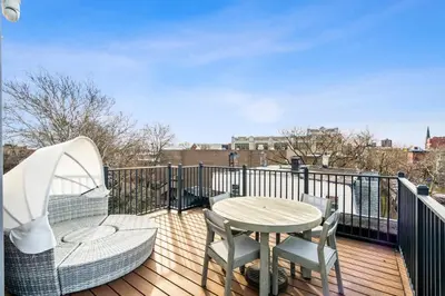a deck with a table and chairs and a table and a table and chairs at Designer Luxury Duplex a few mintues to NYC with Skyline Views in Jersey City