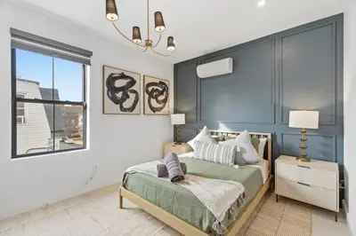 a bedroom with a bed and a large window at Designer Luxury Duplex a few mintues to NYC with Skyline Views in Jersey City