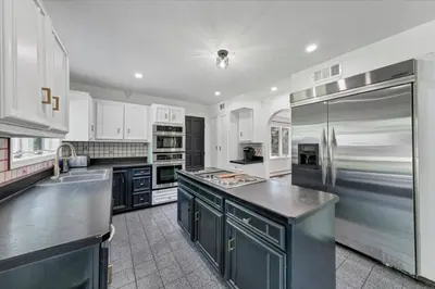 a kitchen with white cabinets and a stainless steel refrigerator at Mediterranean villa hot tub fire place•fire pit in Monroe