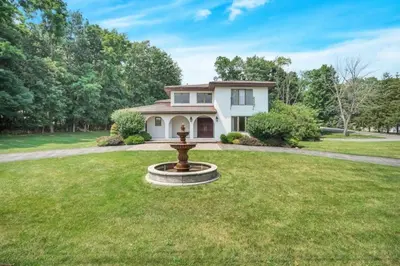a house with a fountain in the middle of a yard at Mediterranean villa hot tub fire place•fire pit in Monroe