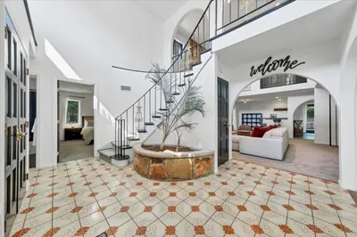 a large living room with a staircase and a potted plant at Mediterranean villa hot tub fire place•fire pit in Monroe