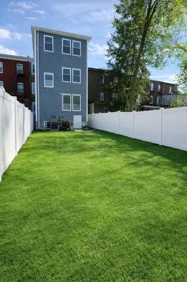 a yard with a white fence and a house at The Signature Modern Flat in Newark