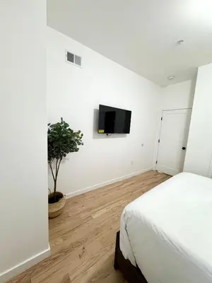 a bedroom with a bed and a tv on the wall at The Signature Modern Flat in Newark