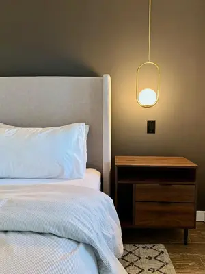 a bedroom with a bed and a nightstand and a lamp at NEW! Montview Chalet - Hot Tub, Sauna, EV, Views in East Stroudsburg
