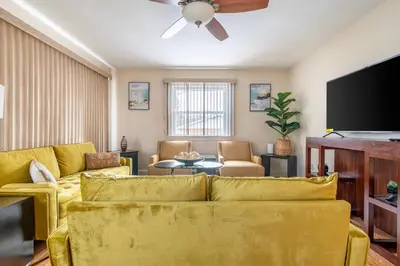 a living room with a yellow couch and a flat screen tv at 5 Woods Dr in Mechanicsburg