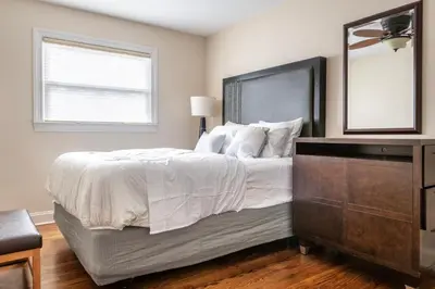 a bedroom with a bed with a dresser and a mirror at 5 Woods Dr in Mechanicsburg
