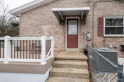 a brick house with a red door and a white fence at 5 Woods Dr in Mechanicsburg