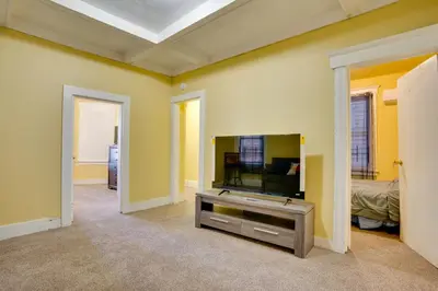 a living room with a flat screen tv on a wall at 2 Mi to Rutgers University! Urban Hub Near Parks in Newark