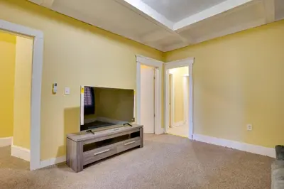 an empty living room with a flat screen tv at 2 Mi to Rutgers University! Urban Hub Near Parks in Newark