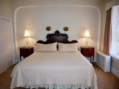 a bedroom with a large white bed with two lamps at Turkey Hill Inn in Summit