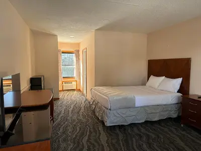 a hotel room with a bed and a desk at Skyline Inn in Mount Pocono