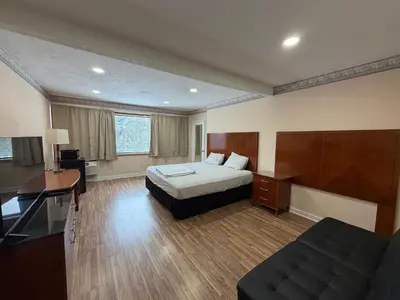 a hotel room with a bed and a desk at Skyline Inn in Mount Pocono