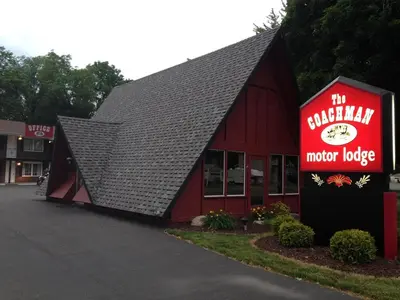 a red building with a motor lodge sign on it at Coachman Motor Lodge in Elmira