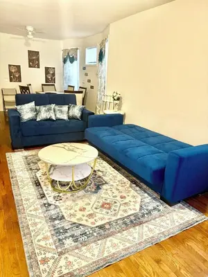 a blue couch in a living room with a table at Enjoyable 3-bedroom house in charming East Orange neighborhood in East Orange