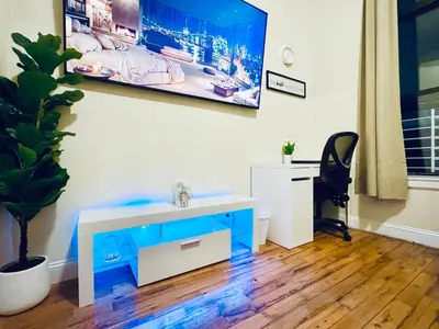 a bathroom with a sink and a tv on a wall at Ultra-Modern Luxury Room Executive Stay Near NYC in Paterson