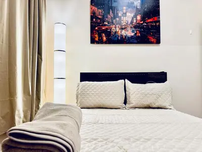 a bedroom with a bed with a poster on the wall at Ultra-Modern Luxury Room Executive Stay Near NYC in Paterson