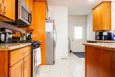 a kitchen with wooden cabinets and a refrigerator at Family Friendly Home in Trolley Square in Wilmington