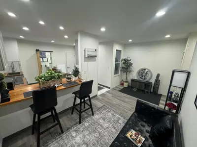 a kitchen and living room with a counter and chairs at 2 bed luxe townhouse-condo NewYork 30 Min Away in Kearny