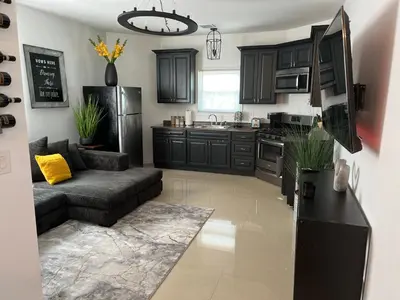 a kitchen with black cabinets and a couch at Secür Your Vacation Home in Jersey City