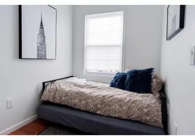 a bed in a room with a window and a bed sidx sidx sidx at Secür Your Vacation Home in Jersey City