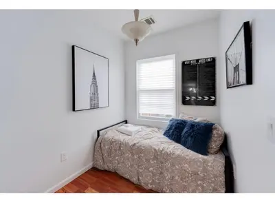 a bedroom with a bed and pictures on the wall at Secür Your Vacation Home in Jersey City