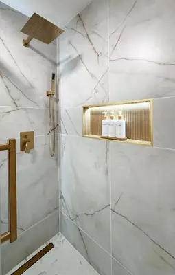 a bathroom with a shower with white marble walls at Blackwood Cabin Pocono in Pocono Farms East