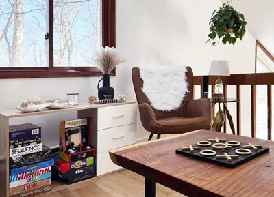 a living room with a table and a chair at Blackwood Cabin Pocono in Pocono Farms East