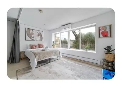 a bedroom with a bed and a large window at Bright and spacious apt, W&D in unit - Monthly in New York