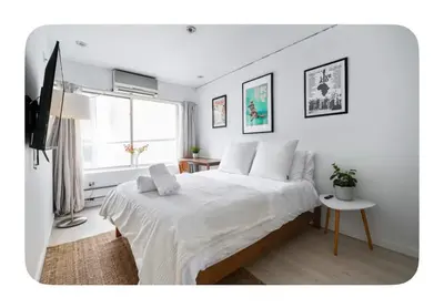 a white bedroom with a large bed and a window at Bright and spacious apt, W&D in unit - Monthly in New York