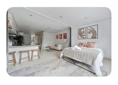 a white bedroom with a bed and a kitchen at Bright and spacious apt, W&D in unit - Monthly in New York