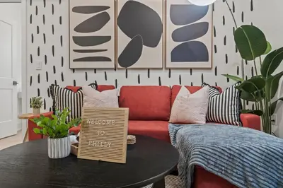 a living room with a red couch and a table at Urban 1BR Apartment Near Center City & University City in Philadelphia