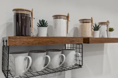 a shelf with coffee cups and plants on it at Urban 1BR Apartment Near Center City & University City in Philadelphia