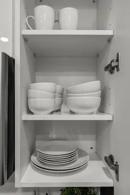 a cabinet filled with plates and bowls and dishes at Urban 1BR Apartment Near Center City & University City in Philadelphia