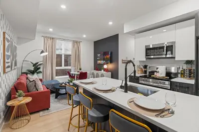 a kitchen and living room with a large island with chairs at Urban 1BR Apartment Near Center City & University City in Philadelphia