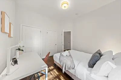 a white bedroom with a bed and a desk at Park Hamilton House 3B2B Modern Apt Mins to NYC in Jersey City