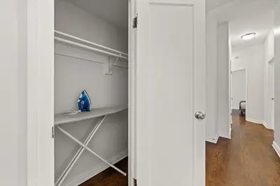 a walk in closet with white walls and wooden floors at Park Hamilton House 3B2B Modern Apt Mins to NYC in Jersey City