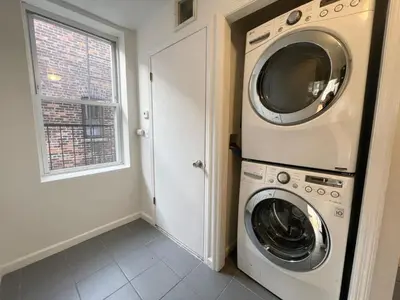 a washer and dryer in a room with a window at Park Hamilton House 3B Top Floor Apt Mins to NYC in Jersey City