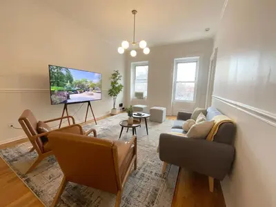 a living room with a couch and a flat screen tv at Park Hamilton House 3B Top Floor Apt Mins to NYC in Jersey City